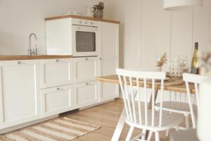 a kitchen with white cabinets and a table and chairs at Im Fachwerk – Wohlfühlen, Entspannen & Wandern im Grünen in Gladenbach