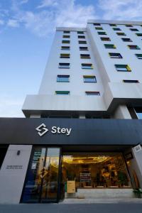 a building with a sign on the front of a store at Stey Beijing 798 Art Zone Hotel in Beijing