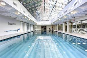 uma grande piscina interior com um tecto de vidro em Penn Quarter 1BR w Gym Pool Doorman nr Metro WDC-159 em Washington