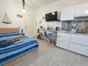 a bedroom with a bed and a kitchen with a counter at Alloggio in residence con pontile privato e accesso diretto al mare in Santa Marinella