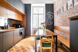 a kitchen with a wooden table and a brick wall at Warsaw Center 110 m2 Spacious and Elegant Apartment in Warsaw