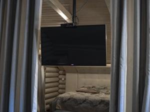 TV de pantalla plana colgada sobre una cama a través de una ventana en Номер Стандарт, 