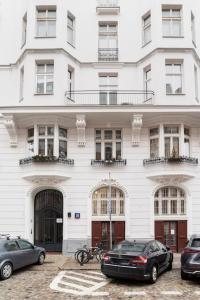 a white building with cars parked in front of it at Warsaw Center 110 m2 Spacious and Elegant Apartment in Warsaw
