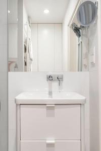 a white bathroom with a sink and a mirror at Warsaw Center 110 m2 Spacious and Elegant Apartment in Warsaw