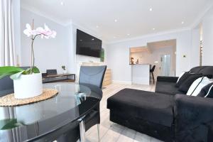 a living room with a couch and a glass table at Colindale Retreat, Sleeps 6 people in Colindale