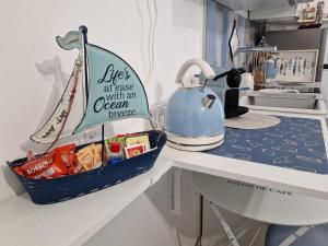 a kitchen counter with a tea kettle on a table at Alloggio in residence con pontile privato e accesso diretto al mare in Santa Marinella