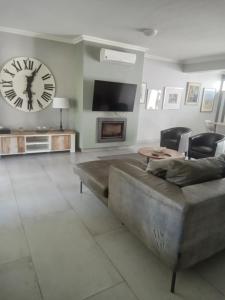 a living room with a large clock on the wall at Franschhoek - La Petit Village - CENTRAL in Franschhoek