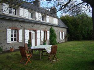 a table and chairs in front of a house at Entre Mont St Michel et Merveille in Vains