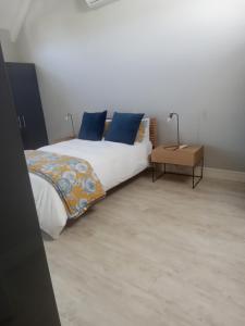 a bedroom with a bed with blue pillows at Franschhoek - La Petit Village - CENTRAL in Franschhoek