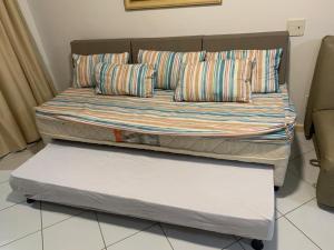 ein Bett mit zwei Kissen auf einem Zimmer in der Unterkunft Apartamento 02 Porto Praia do Forte in Praia do Forte