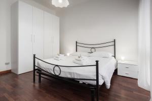 Dormitorio blanco con cama negra con sábanas blancas en Flats4Rent Lucia, en Verona