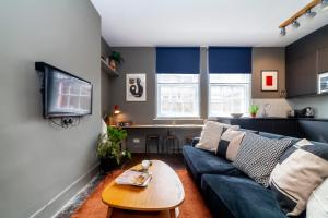 a living room with a blue couch and a table at Beautiful and Spacious 1BR apt, Bethnal green in London