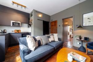 a living room with a blue couch and a kitchen at Beautiful and Spacious 1BR apt, Bethnal green in London