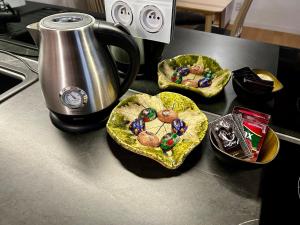 three bowls of food on a counter next to a kettle at Old Cracow Apartment in Krakow