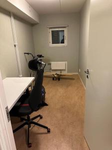 ein Büro mit einem Schreibtisch und einem Stuhl in einem Zimmer in der Unterkunft Trevlig lägenhet i Kista in Stockholm