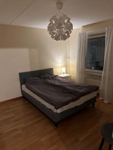 a bed in a bedroom with a chandelier at Trevlig lägenhet i Kista in Stockholm