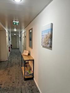 a hallway in an office with a painting on the wall at Hotel du Porge in Le Porge +37 photos