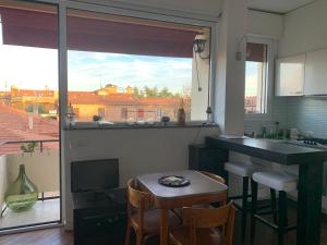 een keuken met een tafel en een keuken met een raam bij Charming Home Towers-Roofs View in Bologna