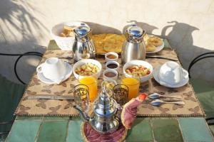 a table with food and drinks on a table at Riad Basma Fes - Tranquil Getaway in Fès +21 photos