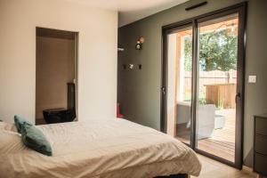 a bedroom with a bed and a sliding glass door at VILLA DREAM LANDES Piscine tempérée-Jacuzzi-5 suites parentales in Moliets-et-Maa +38 photos