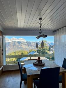 uma sala de jantar com uma mesa e uma grande janela em Chalet Windegg - CharmingStay em Flumserberg