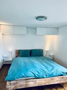 a bedroom with a bed with a blue comforter at Chalet Windegg - CharmingStay in Flumserberg