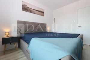 a bedroom with a blue bed and a night stand at Einpark Fabulous Apartment with Private parking in Bratislava
