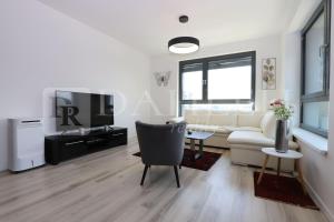 a living room with a couch and a tv at Einpark Fabulous Apartment with Private parking in Bratislava