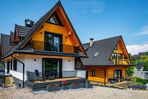 a wooden house with a black roof at Chata Herkulesa in Zakopane