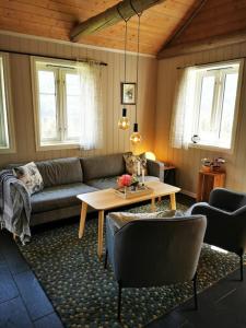 a living room with a couch and a table at Nydelig lite hus med egen vedfyrt baksteovn. in Kaupanger