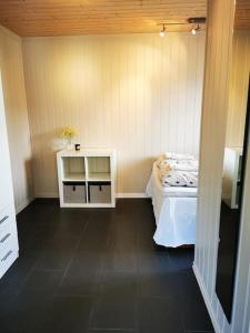 Cette petite chambre comprend un lit et une table. dans l'établissement Nydelig lite hus med egen vedfyrt baksteovn., à Kaupanger