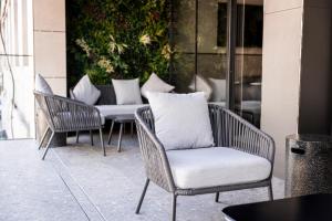 un grupo de sillas y mesas en un patio en The Londoner Hotel St. Julian's, en San Julián