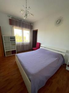 a bedroom with a purple bed and a chair at Casa da Miki e Ico in Zelo