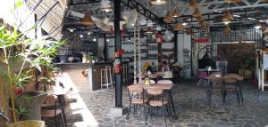 a restaurant with tables and chairs and a bar at 360 Homestay Padang in Kampungdurian