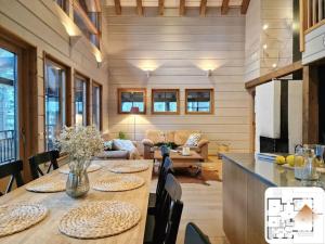 a living room with a wooden table and chairs at Upea Alppitalo Tahkolla in Tahkovuori