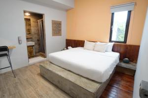 a bedroom with a large white bed and a window at 山森三室墾丁包棟民宿3Rooms in Nanwan