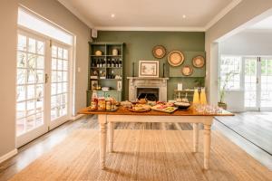 - une salle à manger avec une table et de la nourriture dans l'établissement Corner House Residence, à Franschhoek