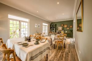 a dining room with two tables and a kitchen at Corner House Residence in Franschhoek