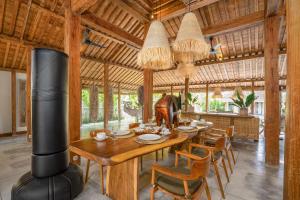 a dining room with a wooden table and chairs at Villa Almar in Dalung