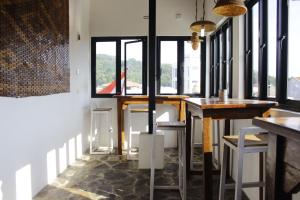 a room with tables and stools and windows at 360 Homestay Padang in Kampungdurian +30 photos
