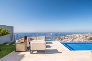 a woman sitting on a couch on the roof of a house at Villa Boa Nova Verde by LovelyStay in Funchal