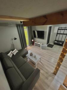 a living room with a couch and a tv at Dębowy Zakątek in Dębowa Wola