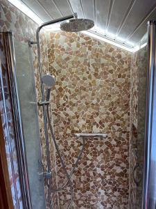 ein Bad mit einer Dusche und einer Steinmauer in der Unterkunft Rustikale Wohnung mit Garten in Allensbach + 29 Fotos