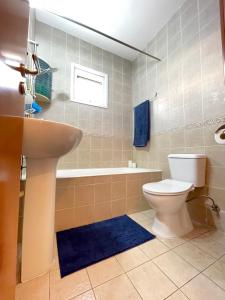 a bathroom with a toilet and a sink and a tub at Anastasia Holiday Apartment Larnaca in Larnaka +15 photos