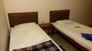 two beds in a small room at Hotel Casa Di William Khajuraho in Khajurāho