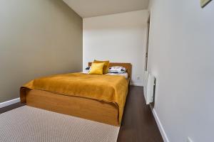 a small bedroom with a bed with a yellow pillow at Charmant Duplex 2 chambres pour 6 personnes - 10 min Disneyland - Free Parking in Bailly-Romainvilliers
