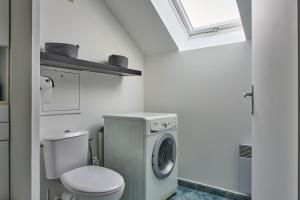 a bathroom with a toilet and a washing machine at Charmant Duplex 2 chambres pour 6 personnes - 10 min Disneyland - Free Parking in Bailly-Romainvilliers