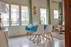 a dining room with a blue table and white chairs at Charmant Duplex 2 chambres pour 6 personnes - 10 min Disneyland - Free Parking in Bailly-Romainvilliers