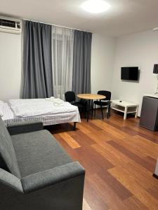 a room with a bed and a table and chairs at Modern Apartments Uzhgorod in Uzhhorod