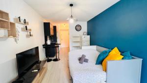 - un salon avec un canapé et un mur bleu dans l'établissement Les Appartements De Lina By LG Immo -Studio Abri-côtier - Self Check-In -, à La Grande Motte